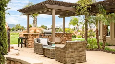 a patio with an outdoor bar with rattan furniture at Secluded Estate Exclusive Views of Wine Country Private Home Theater Twilight Vines by AvantStay in Sage