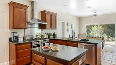 a kitchen with wooden cabinets and a counter top at Grapevine by AvantStay Secluded 5BR Villa 4 Acres of Vineyards Avo Groves in Temecula