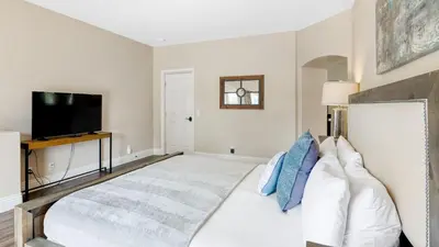 a bedroom with a bed and a flat screen tv at Grapevine by AvantStay Secluded 5BR Villa 4 Acres of Vineyards Avo Groves in Temecula
