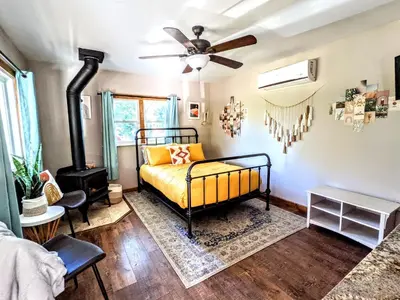 a bedroom with a bed and a wood stove at The Bluebird's Nest - Cabin with Fireplace in Santa Ysabel