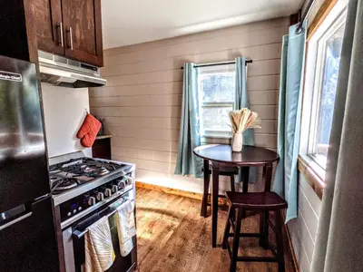 a kitchen with a stove and a small table at The Bluebird's Nest - Cabin with Fireplace in Santa Ysabel