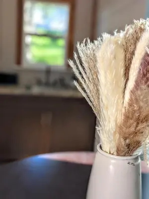 a white vase filled with feathers on top of a table at The Bluebird's Nest - Cabin with Fireplace in Santa Ysabel