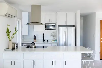 a white kitchen with white cabinets and a refrigerator at Avalon 2 Unit Buyout II IV by AvantStay Mins to Gaslamp Patio w BQQ in San Diego
