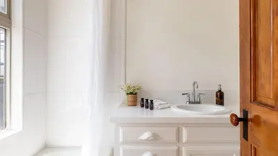 a white bathroom with a sink and a mirror at Bay View I by AvantStay Stylish Mission Beach Home on the Sand in San Diego