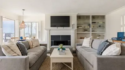a living room with two couches and a fireplace at Bay View I by AvantStay Stylish Mission Beach Home on the Sand in San Diego