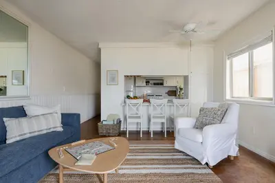 a living room with a blue couch and a table at Bay View 3 by AvantStay Stunning Home on the Beach In Mission Beach in San Diego