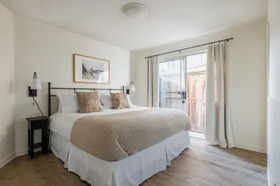 a white bedroom with a large bed and a window at Bay View 3 by AvantStay Stunning Home on the Beach In Mission Beach in San Diego