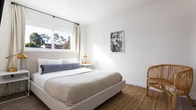 a bedroom with a bed and a chair and a window at Avalon Buyout by AvantStay Mins to Gaslamp Rooftop w BBQ Patio in San Diego