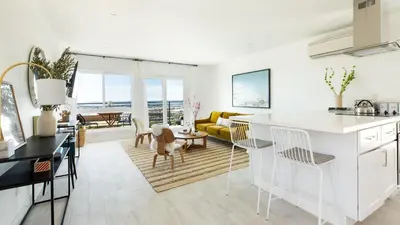 a kitchen and living room with a view of the ocean at Avalon Buyout by AvantStay Mins to Gaslamp Rooftop w BBQ Patio in San Diego