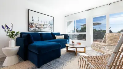 a living room with a blue couch and a chair at Avalon Buyout by AvantStay Mins to Gaslamp Rooftop w BBQ Patio in San Diego