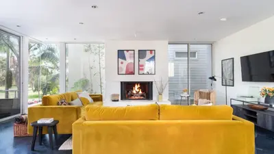 a living room with a yellow couch and a fireplace at Balboa I by AvantStay - Stylish Condo Balboa Park Adjacent w Views in San Diego