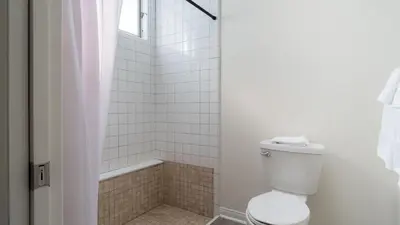 a white bathroom with a toilet and a shower at Balboa Buyout by AvantStay - Condo w Views in DT San Diego in San Diego