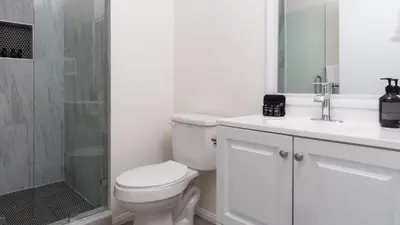 a white bathroom with a toilet and a shower at Balboa Buyout by AvantStay - Condo w Views in DT San Diego in San Diego