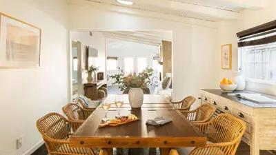 a dining room with a wooden table and chairs at Sand Castle by AvantStay Beach House on Balboa Peninsula w Patio Hot Tub in Newport Beach