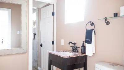 a bathroom with a sink and a mirror at Sand Castle by AvantStay Beach House on Balboa Peninsula w Patio Hot Tub in Newport Beach