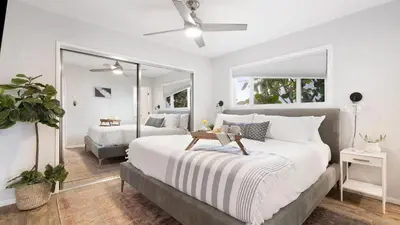 a bedroom with a large white bed and a mirror at Mission Point 1 by AvantStay San Diego Beach House w Huge Patio Fire Pit Walk to Beach in San Diego