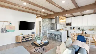 a living room with a couch and a kitchen at Mission Point 2 by AvantStay Mission Beach Home w Large Balcony Steps to Beach in San Diego