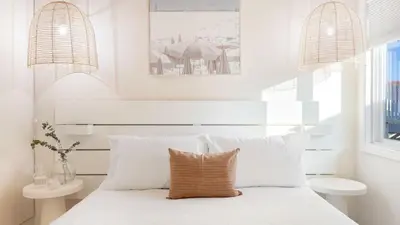 a white bedroom with a white bed with white pillows at Mission Point 2 by AvantStay Mission Beach Home w Large Balcony Steps to Beach in San Diego