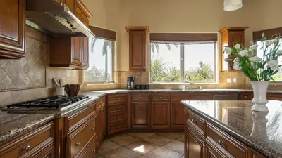 a kitchen with wooden cabinets and a stove top oven at Sangiovese By AvantStay Spectacular Estate w Pool Hot Tub Putting Green in Temecula