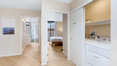 a kitchen and living room with a washer and dryer at Beachfront Home w Ocean Views • Right on Mission Beach Belmont by AvantStay in San Diego