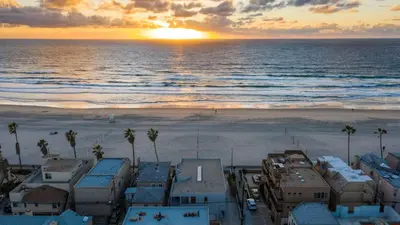 an aerial view of the beach at sunset at Beachfront Home w Ocean Views • Right on Mission Beach Belmont by AvantStay in San Diego