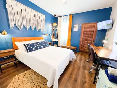 a bedroom with a bed and a desk and blue walls at ITH San Diego Mission Beach Backpacker Hostel in San Diego