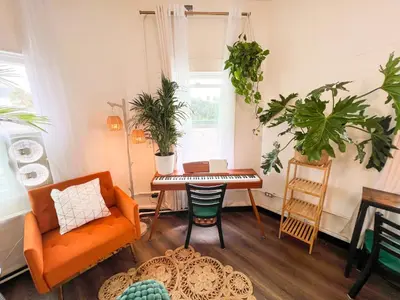 a living room with an orange chair and a table with plants at ITH San Diego Mission Beach Backpacker Hostel in San Diego