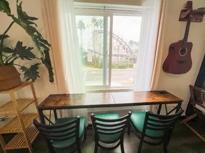 a dining room table with chairs and a guitar on the wall at ITH San Diego Mission Beach Backpacker Hostel in San Diego