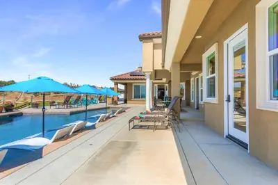 a patio with chairs and umbrellas next to a pool at Gaia Inn & Spa- Adult Only- Temecula Wine Country in Temecula