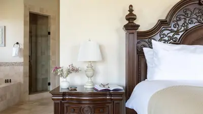 a bedroom with a bed and a table with a lamp at Palazzo Del Sol By AvantStay Breathtaking Home w Mountain Views Hot Tub in Temecula