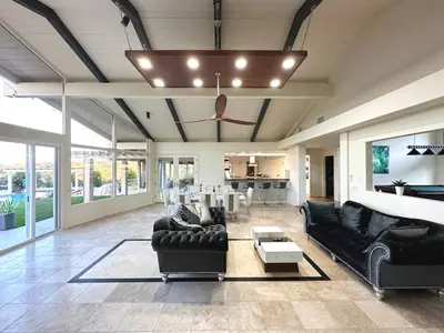 a living room with black leather furniture and a ceiling at Hilltop Villa, Pool Oasis, Pickleball Court, Avocado Grove, Views in Fallbrook