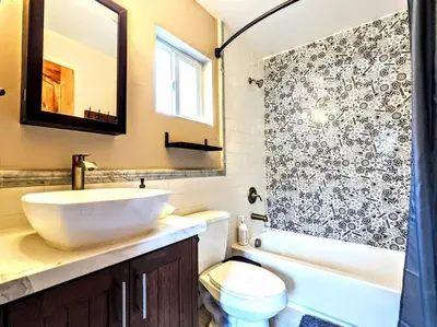 a bathroom with a sink and a toilet and a mirror at The Luminous Lodge-Remodeled Cabin W/ Valley Views in Santa Ysabel