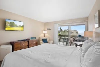 a bedroom with a bed and a view of a balcony at Whitewater Village Retreat B in Oceanside