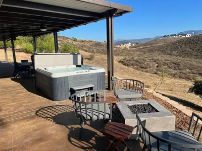 a hot tub on a patio with chairs and a table at Winery Getaway with Spa and Amazing Hilltop View in Temecula