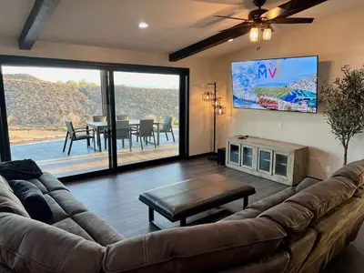 a living room with a large couch and a tv at Winery Getaway with Spa and Amazing Hilltop View in Temecula