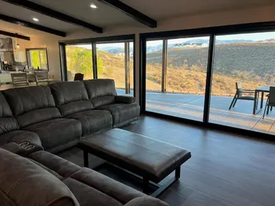 a living room with a leather couch and a table at Winery Getaway with Spa and Amazing Hilltop View in Temecula
