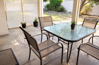 a glass table and chairs on a patio at Starlight Western Room in Hemet