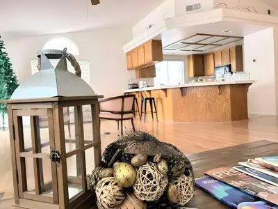 a kitchen and living room with a table with a lantern at Stallion Crest Suite with TV and private bathroom in Hemet