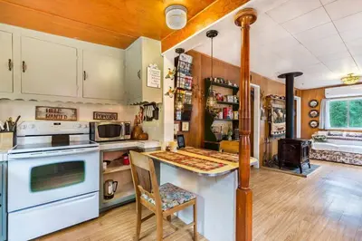 a kitchen with a stove and a table with a chair at Historical Cabin in Julian Pet's okay! in Julian