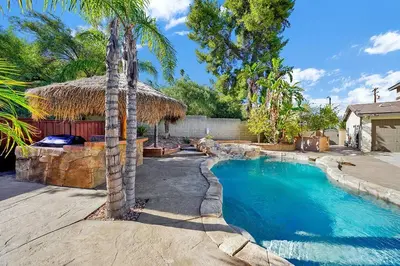 a swimming pool with a palm tree in a yard at Pool-BBQ-View-Balcony-Fireplace-King-Garage-WD in Lake Elsinore