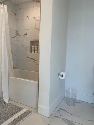 a bathroom with a shower and a tub and a toilet at Luxury Designer Suite with Rooftop Pool, Gym in San Diego