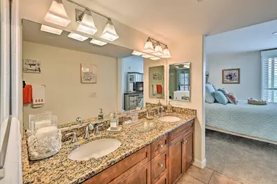 a bathroom with two sinks and a bedroom at Breezy Oceanside Condo Less Than half Mi to Beach! in Oceanside