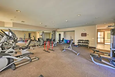 a gym with several treadmills and machines in a room at Breezy Oceanside Condo Less Than half Mi to Beach! in Oceanside