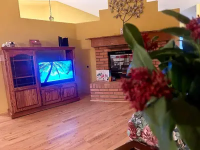 a living room with a television and a fireplace at Rosewood Retreat in Hemet