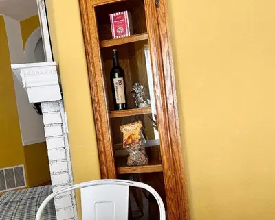 a shelf with a bottle of wine and a chair at Rosewood Retreat in Hemet