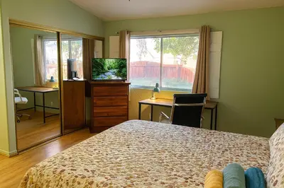 a bedroom with a bed and a television and a desk at Meadow Harvest Suite with TV and private bathroom in Hemet