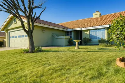 a house with a tree in a yard at Meadow Harvest Suite with TV and private bathroom in Hemet