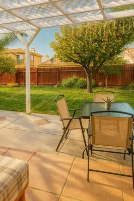 a patio with a table and chairs under a pergola at Meadow Harvest Suite with TV and private bathroom in Hemet
