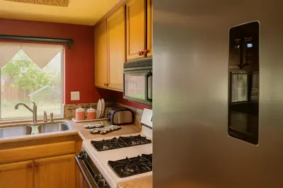 a kitchen with a stove top oven next to a sink at Wildflower Haven room in Hemet