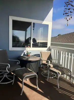 a balcony with chairs and a table and a window at Blue Whale Inn San Clemente Retreat Unit E in San Clemente